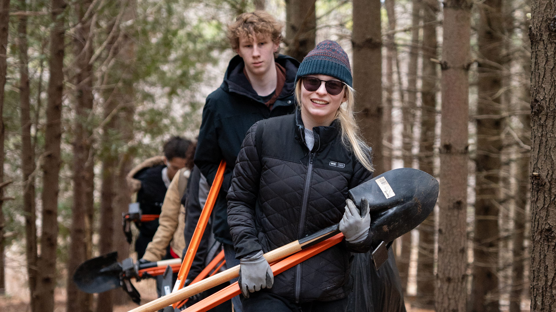 People carrying shovels in a forest
